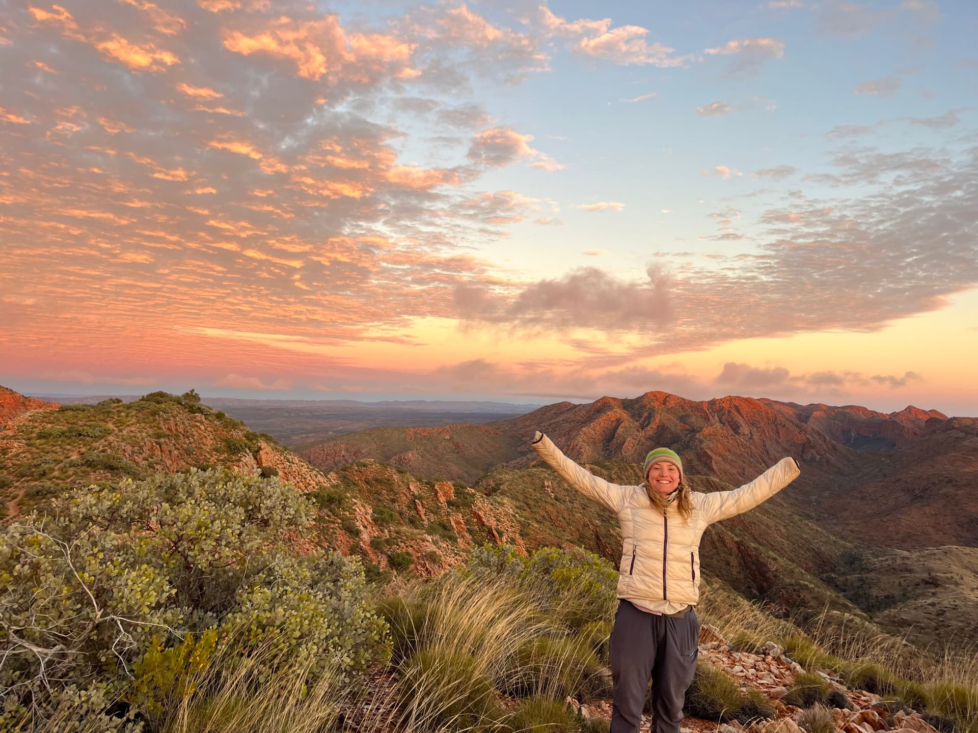 Participant celebrating on a mountain summit at sunrise